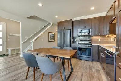 a kitchen with a wooden table and blue chairs at Fraser Vacation Rental - Shuttle to Winter Park! in Fraser