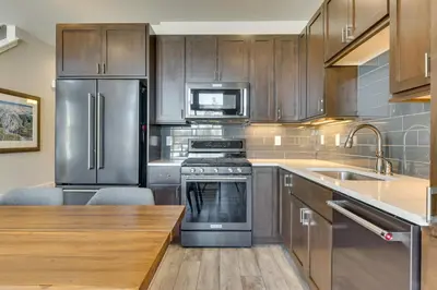 a kitchen with stainless steel appliances and wooden cabinets at Fraser Vacation Rental - Shuttle to Winter Park! in Fraser