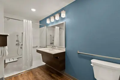 a bathroom with a white toilet and a sink at WoodSpring Suites Fort Collins in Fort Collins