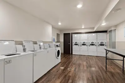 a laundry room with white appliances and a table at WoodSpring Suites Fort Collins in Fort Collins