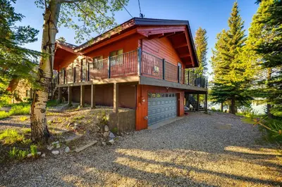 a large house with a balcony and a garage at Hot Tub and Mtn Views Waterfront Grand Lake Cabin! in Grand Lake