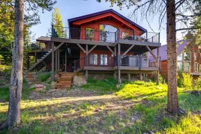 a house in the woods with a balcony at Hot Tub and Mtn Views Waterfront Grand Lake Cabin! in Grand Lake