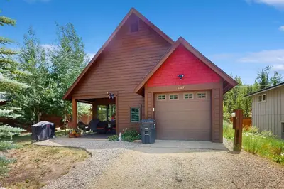 a house with a red roof and a garage at Cozy Cabin Retreat in Grand Lake