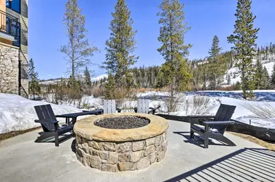 a patio with two chairs and a fire pit at Modern Winter Park Condo with Community Hot Tub! in Winter Park