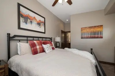 a bedroom with a bed with red pillows and a ceiling fan at Mountain Haus home in Fraser