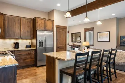 a kitchen with wooden cabinets and a island with bar stools at Mountain Haus home in Fraser