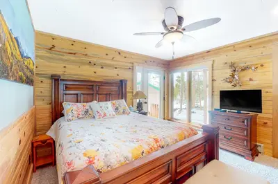 a bedroom with a bed and a flat screen tv at Wapiti Point in Grand Lake