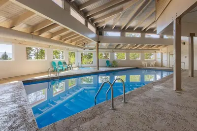 a large swimming pool with blue chairs in a building at Mountain view, kids room, great location! in Silverthorne