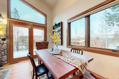a dining room with a table and some windows at Elk Trail Retreat in Winter Park