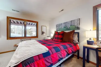 a bedroom with a bed and a desk and a window at Elk Trail Retreat in Winter Park