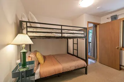 a bedroom with two bunk beds and a lamp at Windwood Alpine Townhome: Downtown Frisco in Frisco