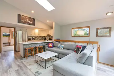a living room with a couch and a kitchen at Windwood Alpine Townhome: Downtown Frisco in Frisco