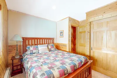 a bedroom with a bed and a lamp on a table at Wapiti Point - Main House in Grand Lake
