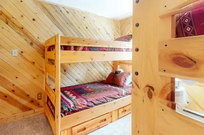 a bedroom with two bunk beds in a log cabin at Wapiti Point - Main House in Grand Lake