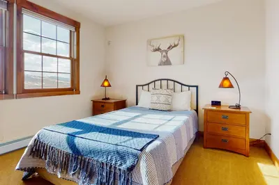 a bedroom with a bed and two lamps and a window at Majestic Mountain Escape in Granby