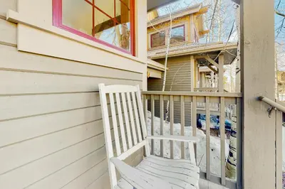 a white chair sitting on the side of a house at Majestic Mountain Escape in Granby